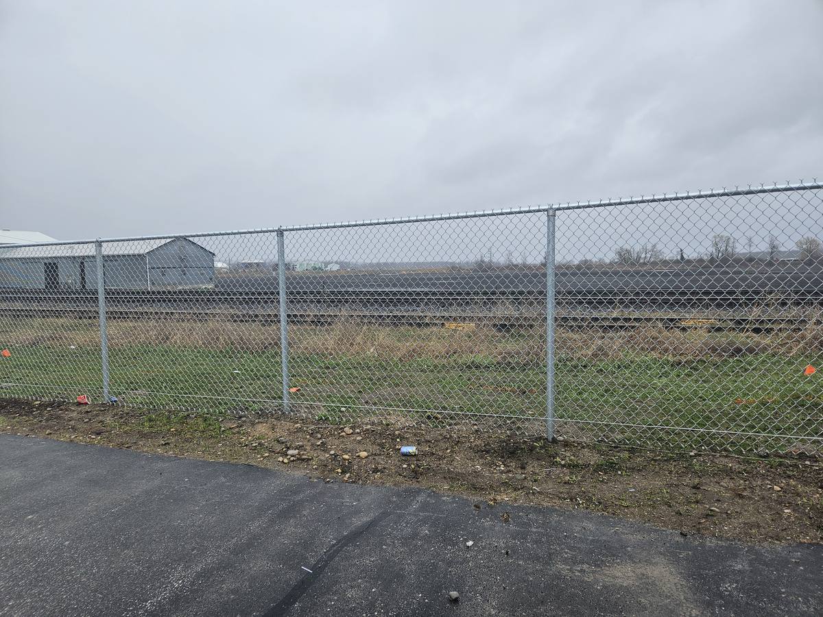 Galvanized chain link fence installed along a rail corridor
